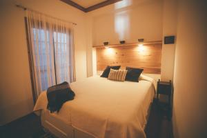 a bedroom with a large white bed with a window at BayView House in Angra do Heroísmo