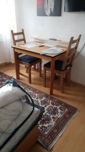a wooden table with two chairs and a rug at Appartement Altstadt Mainz in Mainz