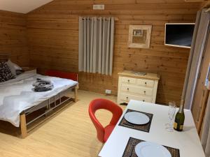 a small room with a bed and a table with a dining room at Southernwood - Garden Lodge 4 in Didcot