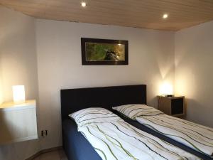 ein Bett in einem Schlafzimmer mit einem Bild an der Wand in der Unterkunft Ferienwohnung Neuss Spelter in Neuss