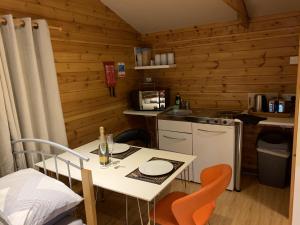 a small kitchen with a table and chairs in a cabin at Southernwood - Garden Lodge 5 in Didcot