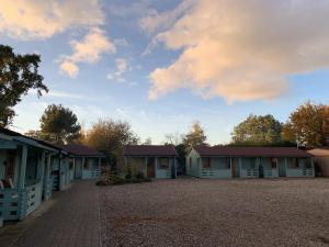 Une rangée de maisons avec des arbres et un ciel nuageux dans l'établissement Southernwood - Garden Lodge 5, à Didcot