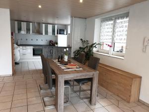 Il comprend une cuisine et une salle à manger avec une table et des chaises en bois. dans l'établissement Ferienwohnung Neuss Spelter, à Neuss