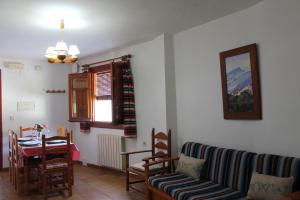 a living room with a couch and a table and a dining room at Apartamentos Rurales Rosendo: El Jazmin in Capileira