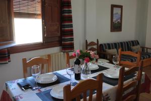 a dining room table with flowers and wine glasses at Apartamentos Rurales Rosendo: El Jazmin in Capileira