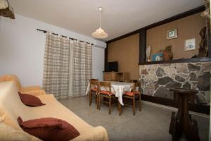 a living room with a table and a stone wall at Apartments Delfin with seaview 100 meters from the sea - by TA Leut Agency in Privlaka