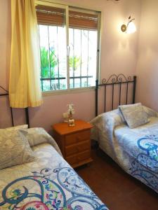 1 dormitorio con 2 camas y ventana en Casa Rural Bellavista Ronda, en Ronda