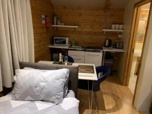 a room with a bed and a table with a laptop on it at Southernwood - Garden Lodge 7 in Didcot