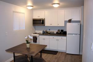 a kitchen with a table and a white refrigerator at Rainier Guesthouse (Walk to Metro) in Seattle