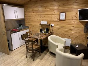 eine Küche und ein Esszimmer mit einem Tisch und Stühlen in der Unterkunft Southernwood - Garden Lodge 8 in Didcot