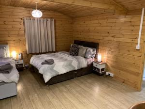 a bedroom with two beds in a log cabin at Southernwood - Garden Lodge 8 in Didcot