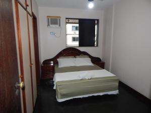 ein Schlafzimmer mit einem Bett in einem Zimmer mit einem Fenster in der Unterkunft Apartamento Praia do Forte in Cabo Frio