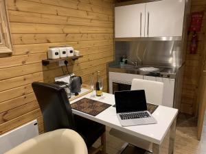 eine Küche mit einem Tisch und einem Laptop darauf in der Unterkunft Southernwood - Garden Lodge 9 in Didcot