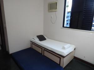 ein kleines Bett in einem Zimmer mit Fenster in der Unterkunft Apartamento Praia do Forte in Cabo Frio