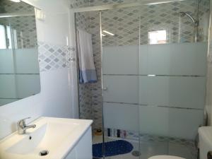 a bathroom with a sink and a shower at Herama Sea Guesthouse in Vila Nova de Gaia