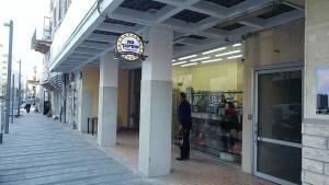 a man is standing outside of a store at Port City Haifa in Haifa