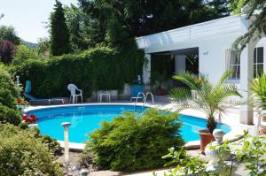 a swimming pool in the yard of a house at Gästehaus Gaens - Ferienwohnung in Schirgiswalde