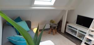 a living room with a blue couch and a television at Appartement Klein Waldeck in Velp