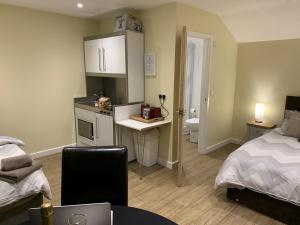 una camera con letto e scrivania e una camera con letto di Southernwood - Garden Lodge 12 a Didcot