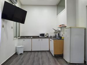 拉巴特的住宿－cosy home，厨房配有白色橱柜和冰箱。