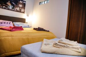 um quarto com duas camas e uma mesa com toalhas em ZazzamitaHouse em Catânia