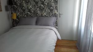 a bedroom with a bed with a black and white headboard at Duplex La Maisonnette 2 Chambres - parking gratuit in Troyes