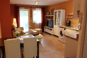 eine Küche und ein Wohnzimmer mit einem Tisch und einem Esszimmer in der Unterkunft Kuschelige Ferienwohnung nahe Kronach in Kronach