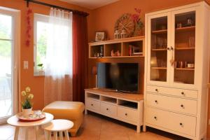 ein Wohnzimmer mit einem TV in einem weißen Schrank in der Unterkunft Kuschelige Ferienwohnung nahe Kronach in Kronach