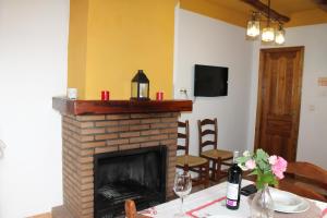 a living room with a fireplace and a table with a table sidx sidx at Apartamentos Rurales Rosendo: La Orquídea in Capileira