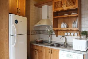 cocina con nevera blanca y fregadero en Apartamentos Rurales Rosendo: La Orquídea en Capileira