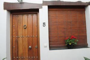 a building with a wooden door and a potted plant at Apartamentos Rurales Rosendo: La Orquídea in Capileira +2 photos