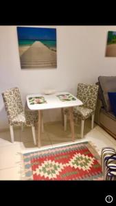 a room with a table and two chairs and a rug at Praia Grande - Edifício Frente ao Mar in Praia Grande