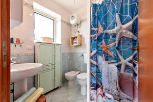 un bagno con un water e una tenda da doccia di Tra Cielo E Mare Del Salento a Santa Maria al Bagno
