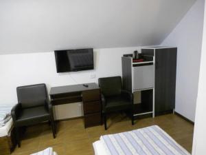 a room with a desk and two chairs and a tv at Gościniec Nad Jarem in Gołdap