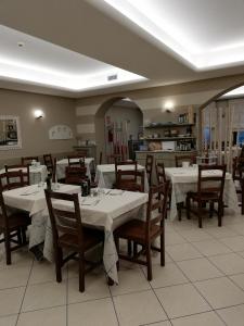 a dining room with white tables and wooden chairs at Albergo Villa Eva in Costermano