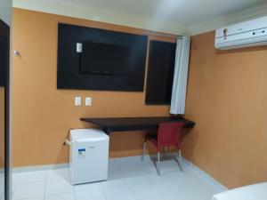 eine Küche mit einem Schreibtisch und einem roten Stuhl in einem Zimmer in der Unterkunft Hotel Executivo Boulevard in Mossoró