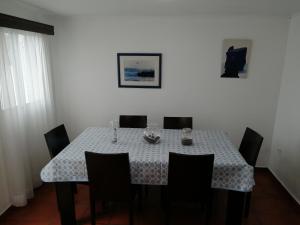 a dining room table with chairs and a blue and white table cloth at Casa Dos Mosteiros in Mosteiros