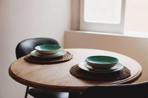 a wooden table with two green bowls on top at Casa Luna in Santa Maria di Castellabate