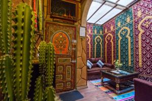 een woonkamer met een bank en een grote houten deur bij Dar Zerbtana Apartment in Fès