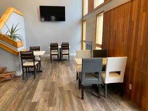 a dining room with tables and chairs and a flat screen tv at Red Lion Inn & Suites Post Falls in Post Falls