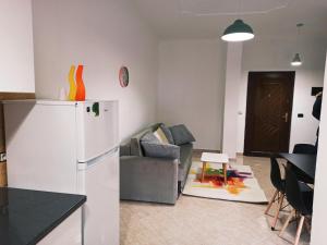 a kitchen and living room with a refrigerator and a couch at Lovely Apartment 2 in Golem