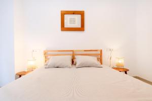 1 dormitorio con 1 cama blanca grande y 2 lámparas en Apartamento Nuevo-Junto a Mezquita en Córdoba