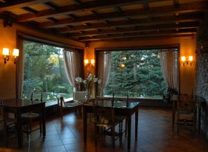 a dining room with a table and a large window at Hotel Celisol Cerdagne in Bourg-Madame
