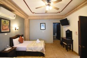 1 dormitorio con 1 cama y ventilador de techo en Hotel Rinconada del Convento, en Izamal