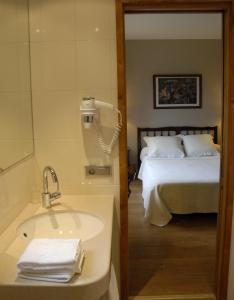 een badkamer met een wastafel en een bed bij Hotel Celisol Cerdagne in Bourg-Madame