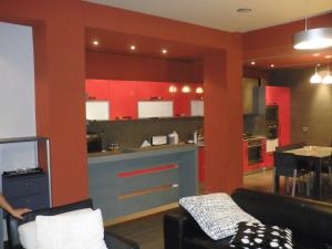 a living room with a kitchen with red cabinets at Bylis Rooms in Golem