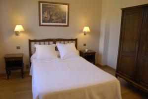 a bedroom with a large white bed with two night stands at Hotel Celisol Cerdagne in Bourg-Madame