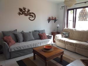 ein Wohnzimmer mit einem Sofa und einem Couchtisch in der Unterkunft Bungalow Playa Bastian - Piscina climatizada - Wifi - Playa 1 min. in Costa Teguise