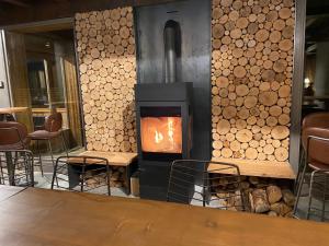 einen Holzofen in einem Zimmer mit Stühlen in der Unterkunft Hôtel LAPIAZ & Spa - FLAINE in Flaine