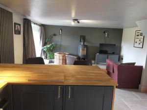 a kitchen with a counter and a living room at Coed Canol Farm in Abergavenny